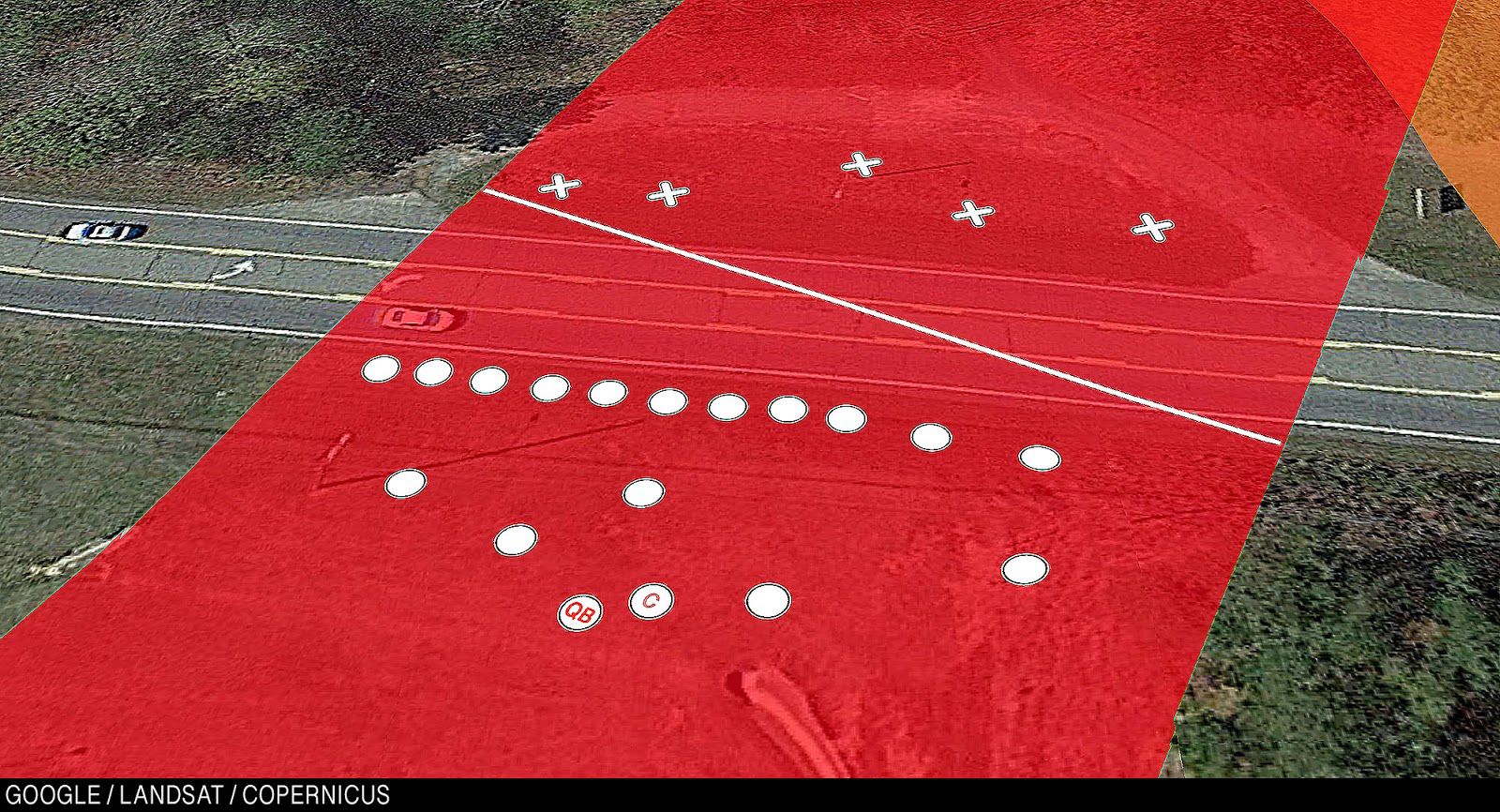 Close-up of the line of scrimmage. The offense outnumbers the defense.